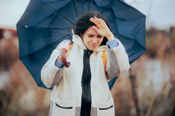 istock Woman Holding Her Umbrella Walking into a Windstorm 1450448984