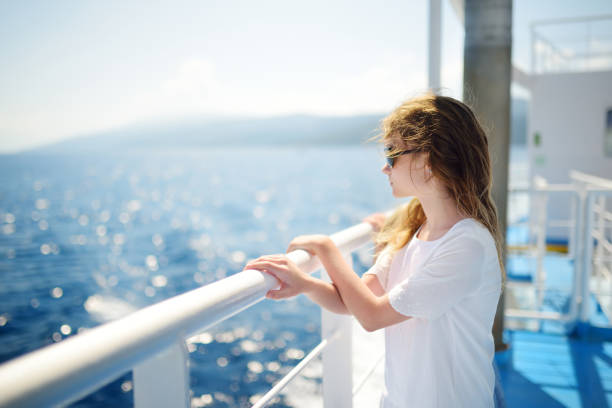 Adorable young girl enjoying ferry ride staring at the deep blue sea. Child having fun on summer family vacation in Greece. Adorable young girl enjoying ferry ride staring at the deep blue sea. Child having fun on summer family vacation in Greece. Kid sailing on a boat. ferry deck girls stock pictures, royalty-free photos & images