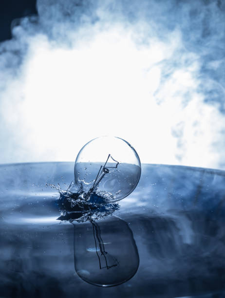 istock Water splash on dark foggy background. Abstract concept. Light bulb dropping on water 1450460487