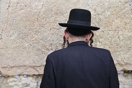 Jerusalem - Nov 15 2022:Orthodox Jewish man pray at the Western Wall a portion of ancient limestone wall in the Old City of Jerusalem that forms part of the larger retaining wall of the Temple Mount.