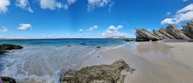 A panoramic view of rocks formation on Thomson Bay beach in Rottnest Island, Australia with blue sky