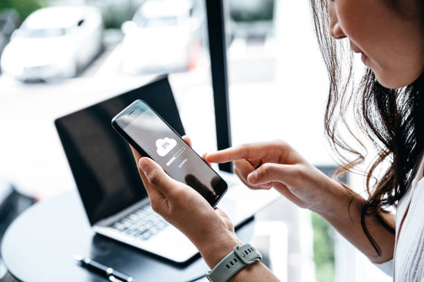 istock Young woman waiting for cloud uploading on smartphone. 1450492157