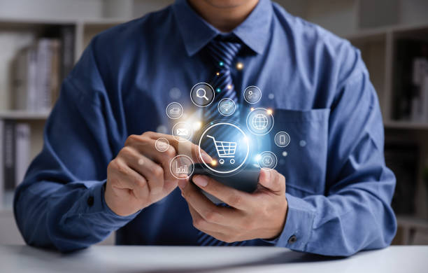 istock Young man using smartphone with shopping cart icon. 1450492214