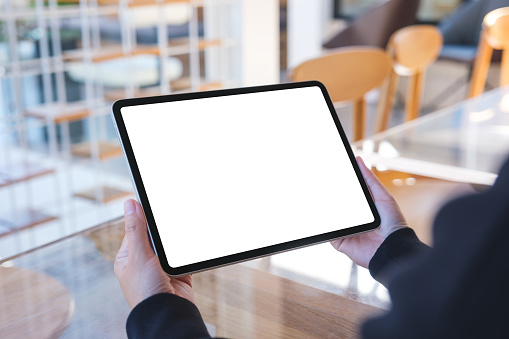 Mockup image of a woman holding digital tablet with blank white desktop screen