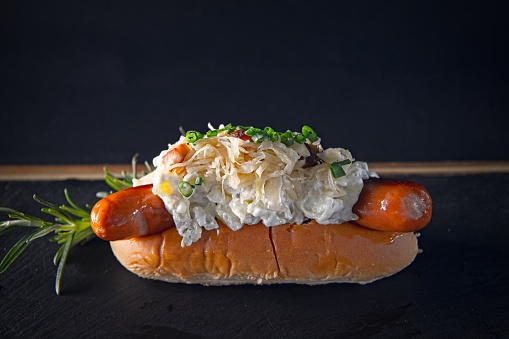 Luxury restaurant artisan hotdog filled with sausage and minced meat or poatato salad. Simple and tasty.