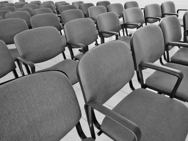 The view of black empty office armchairs placed in a row in the white room