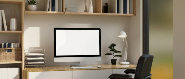 istock Minimalist workspace with PC desktop computer mockup and decor on minimal wood table. 1450513471