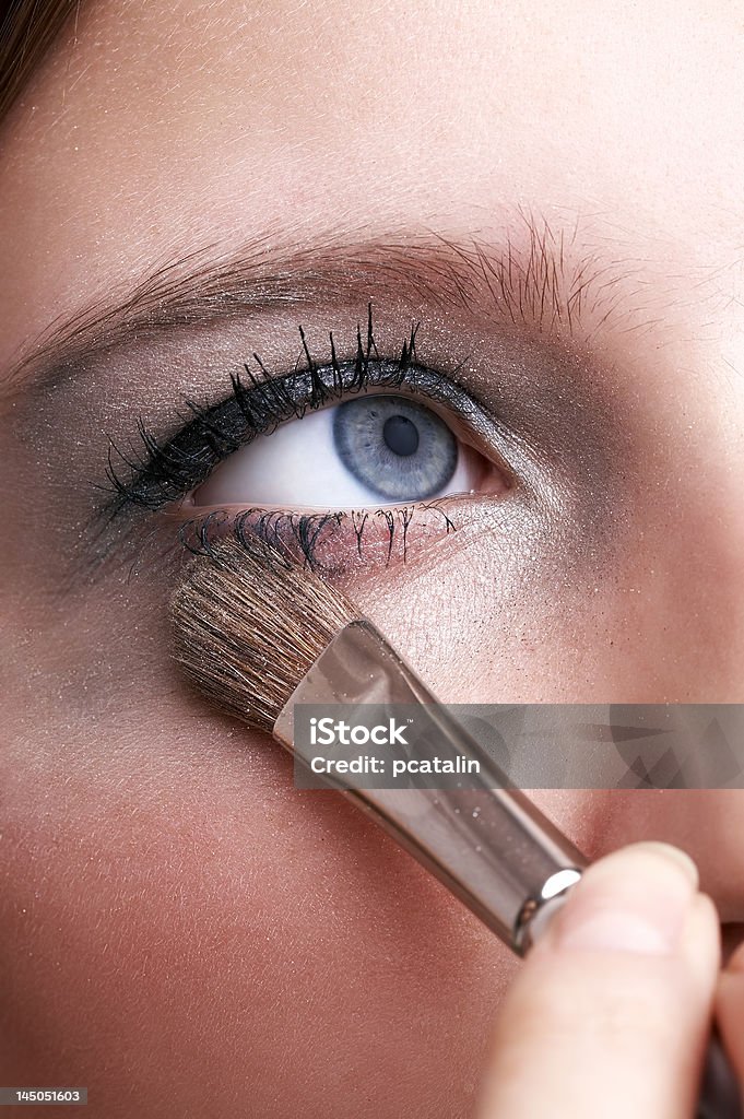 makeup artist applying blue eye powder with brush makeup artist applying blue eye powder with brush, girl with blue eye Adult Stock Photo