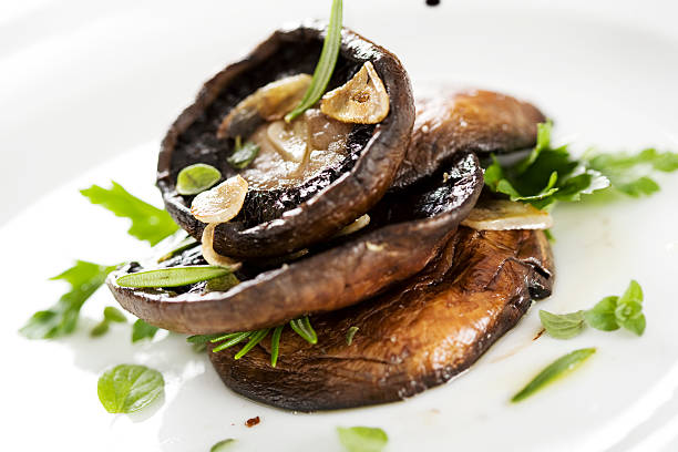 A small pile of some cooked mushrooms  grilled portobello mushrooms, covered in herbs and garlic crimini mushroom stock pictures, royalty-free photos & images