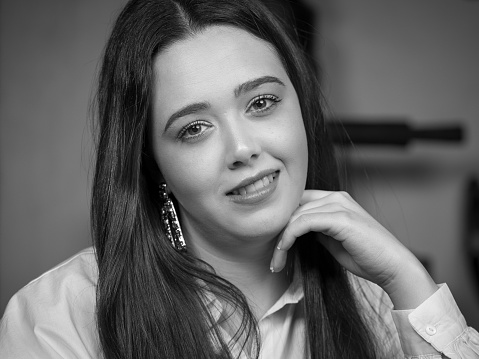 Portrait of young woman smiling and looking straight ahead.