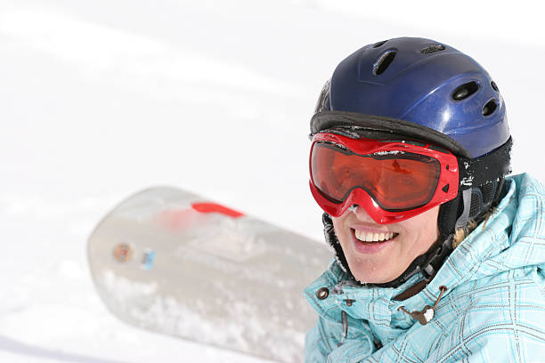 alegre jovem mulher sorrindo para a câmera no snowboard - snowboarding snowboard teenager red - fotografias e filmes do acervo