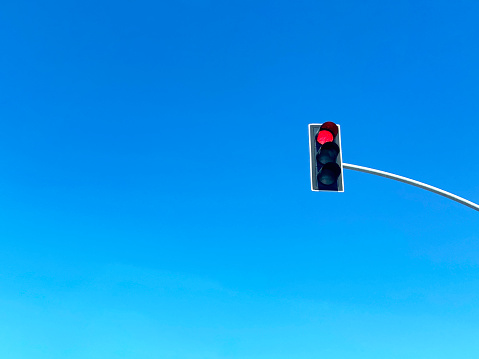 Traffic light with clear sky background. Red stoplight and blue clear sky with copy space