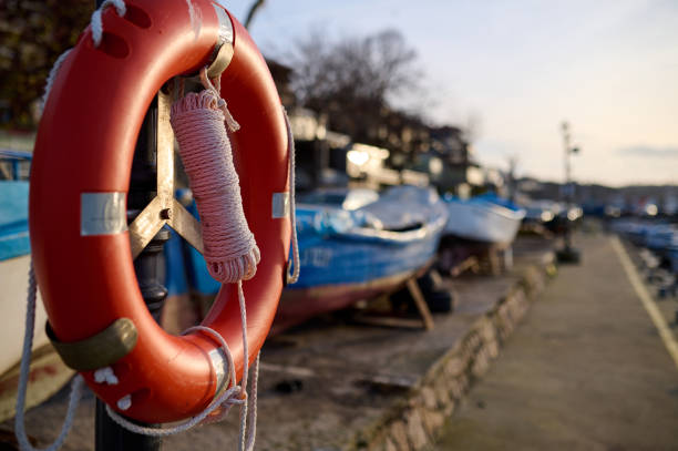 Orange lifebuoy hang on the pier at sunset
