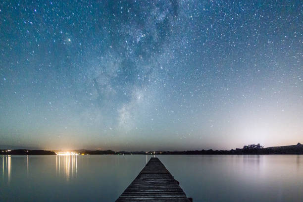 Long wooden pier on the shore with a beautiful sky full of stars in Paihia, New Zealand A long wooden pier on the shore with a beautiful sky full of stars in Paihia, New Zealand bay of islands new zealand stock pictures, royalty-free photos & images