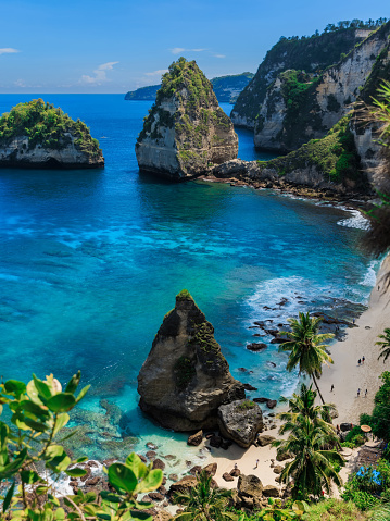 Diamond beach with blue ocean and scenic coastline with rocks and mountain in Nusa Penida