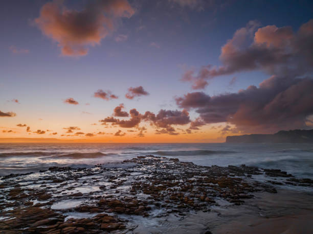 istock Surfs up sunrise at the seaside with scattered clouds 1450552557