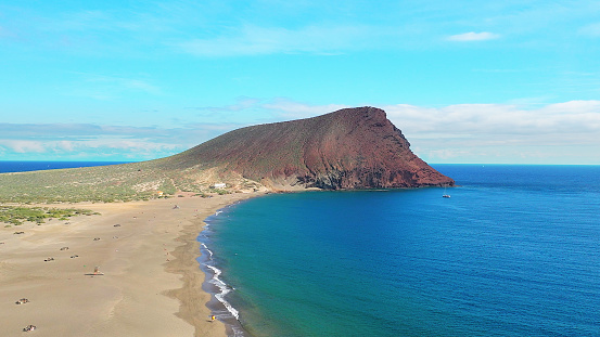 Aerial view of La Tejita Beach and volcanic cone of Montaña Roja, Tenerife, Canary Islands. Drone shot