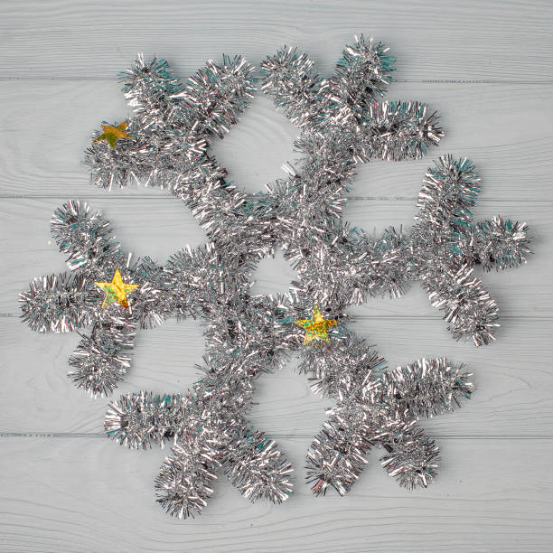 istock Silver decorative christmas snowflake on wooden backgroun 1450561347