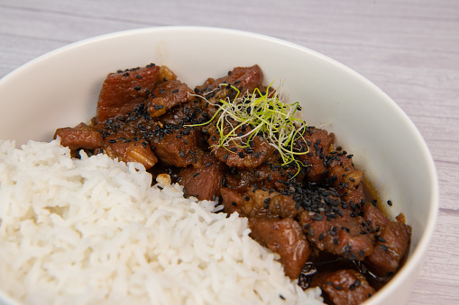 Caramel pork recipe with rice and black sesame seeds. High quality photo
