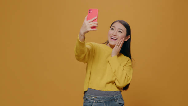 istock Cheerful person taking selfies with smartphone in studio 1450564972
