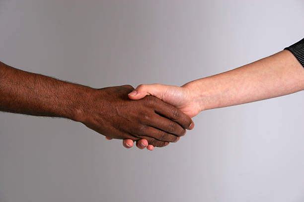 istock Black man and white woman shaking hands 145056550