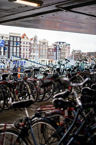 A vertical shot of a bunch of bicycles parked outdoors in Amsterdam