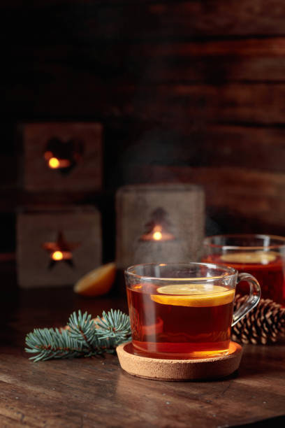 istock Tea with lemon and small Christmas lanterns on a wooden table. 1450568739