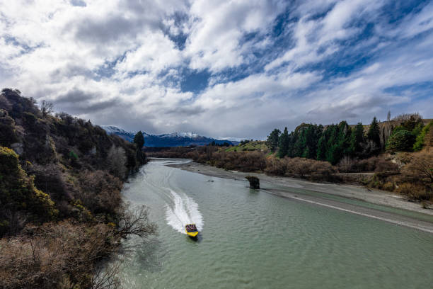 Queenstown, Otago, New Zealand - September 03, 2022: A jet boat powering down Queenstown’s famous Shotover River near Arrowtown.