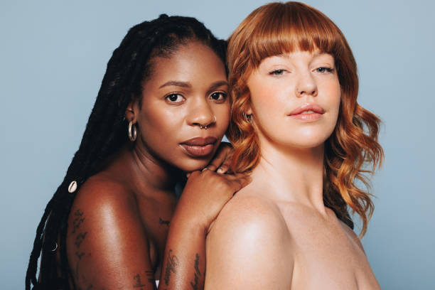 istock Two young women with different skin tones looking at the camera while standing together 1450574441
