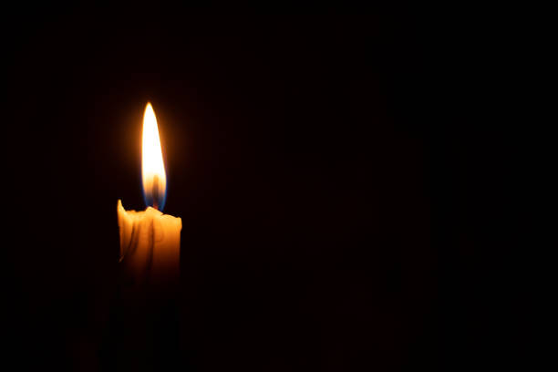 istock single candle flame in the dark as a closeup background 1450574787