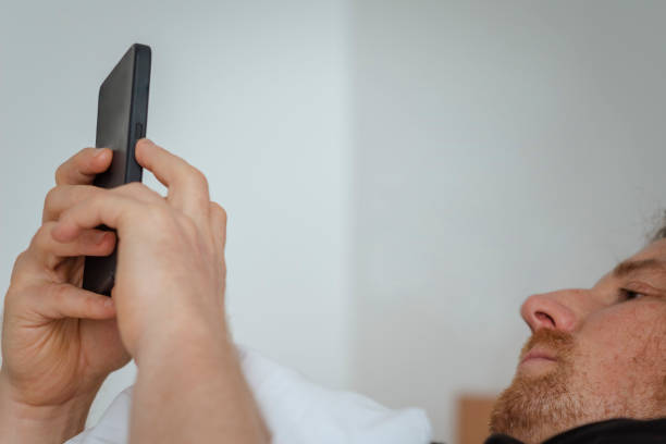 istock Man in bed on his phone 1450575692