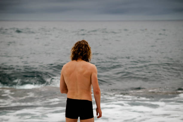 Man at the Atlantic ocean ready for a swim stock photo