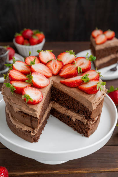 istock Naked chocolate cake with cream and fresh strawberries on top. Rustic style. Selective focus. Copy space. 1450577095