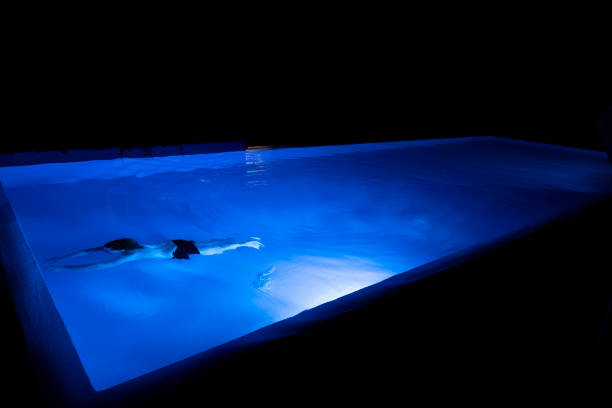 Modern backyard water pool at night.