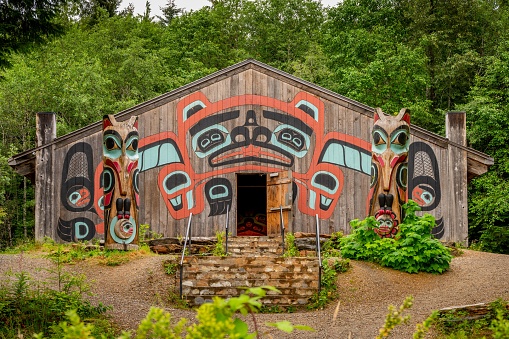 Saxman, United States – July 29, 2022: Saxman, Alaska - July 29, 2022: Tlingit totem poles, long house and traditional art.
