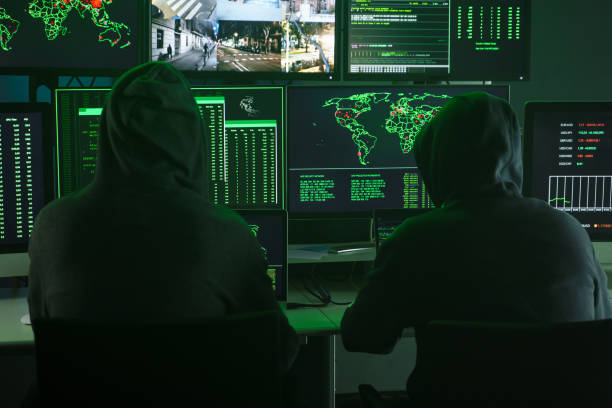 istock Team of Computer hackers coding on keyboard hidden in illegal hideout full of monitors 1450584224