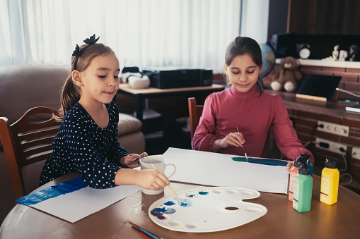 Child Sisters Painting Pictures Together At Home