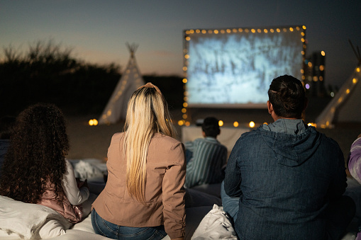 Group of people watching a movie at the outdoors cinema