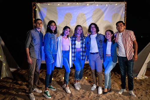 Portrait of young friends at the outdoors cinema or beach party