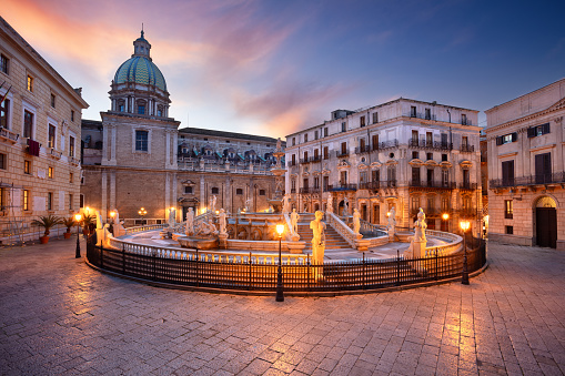 Cityscape image of Palermo, Sicily with  famous Praetorian Fountain located in Piazza Pretoria at sunset.