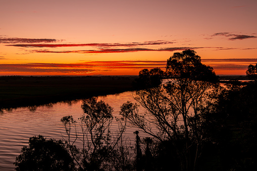 Tailem Bend, South Australia, Australia - July 29, 2022: The sun sets over the Murray River as seen from the regional South Australian town of Tailem Bend a gateway town on the road between Adelaide and both Sydney and Melbourne.