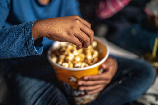 Close-up of child eating popcorn outdoors