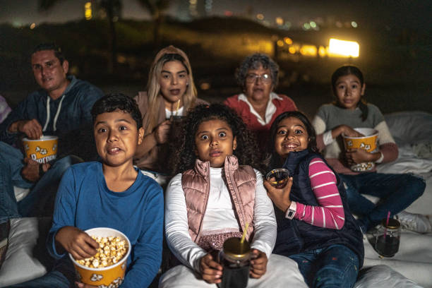 group of people being surprised as they watch a movie outdoors - audience surprise movie theater shock imagens e fotografias de stock