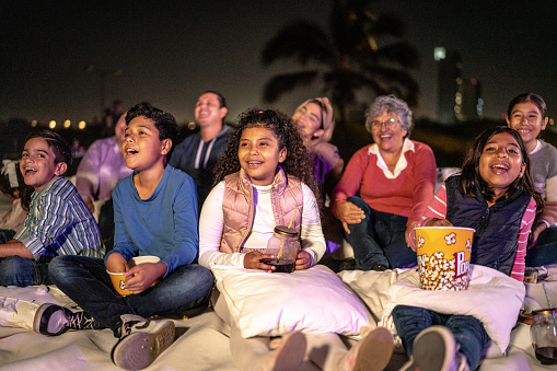 Group of people enjoying a movie at the outdoors cinema