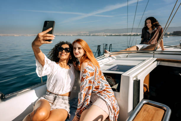 istock Female friends taking selfie while riding on a yacht together 1450589997