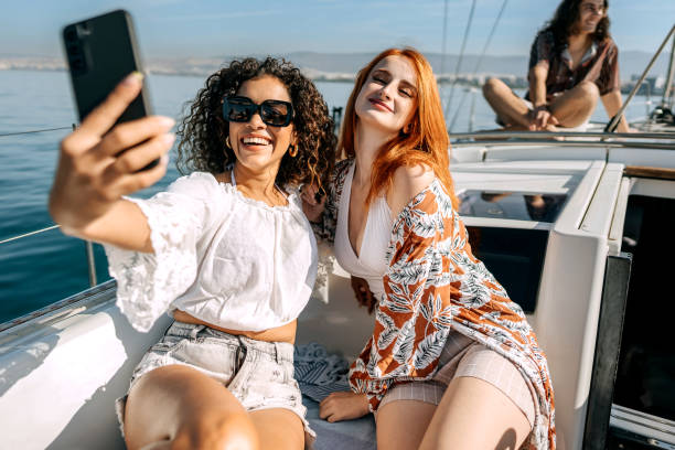 istock Female friends taking selfie while riding on a yacht together 1450590004