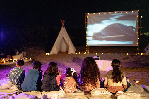 Group of children watching a movie outdoors