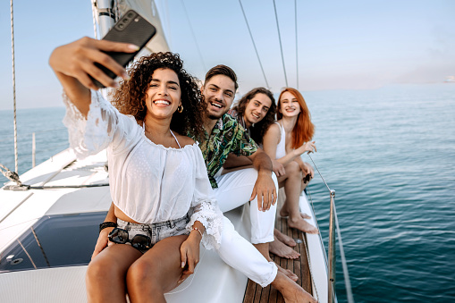 Group of friends taking selfie while riding on a yacht
