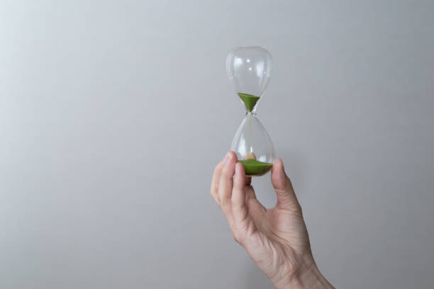 tenant un sablier - sand clock human hand hourglass photos et images de collection