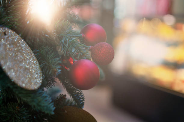 christmas ball or ornaments on tree in evergreen with sunlight